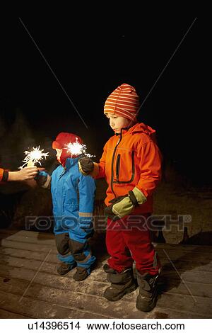 Picture - Boys playing with sparkler outdoors. Fotosearch