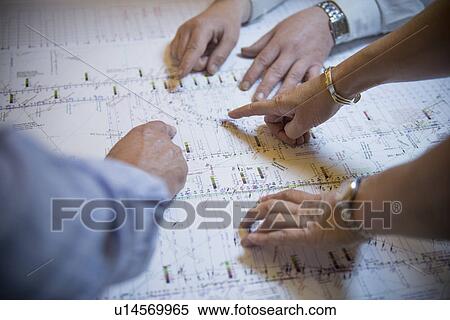 Stock Photography - Business people reading coal mine plans. Fotosearch