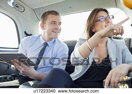 Business people riding in taxi together View Large Photo Image Stock Image - Business people riding in taxi together. Fotosearch