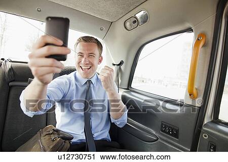 Businessman cheering on cell phone View Large Photo Image Stock Image - Businessman cheering on cell phone. Fotosearch