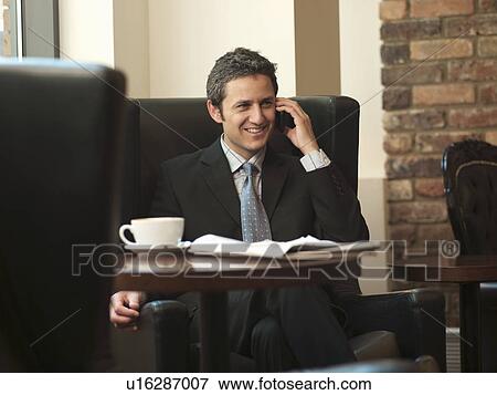 Businessman on cell phone in cafe View Large Photo Image Stock Photo - Businessman on cell phone in cafe. Fotosearch