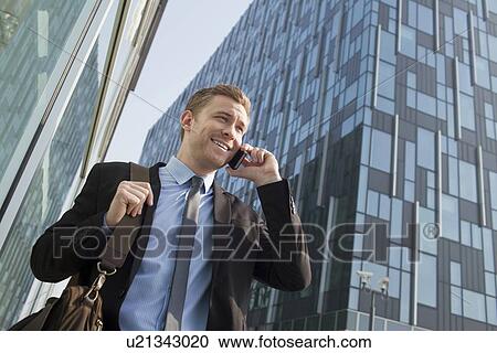 Businessman on cell phone outdoors View Large Photo Image Stock Image - Businessman on cell phone outdoors. Fotosearch