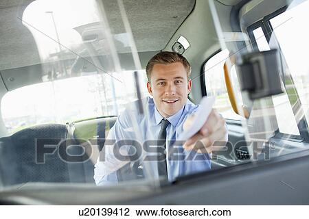 Businessman paying taxi driver View Large Photo Image Stock Image - Businessman paying taxi driver. Fotosearch