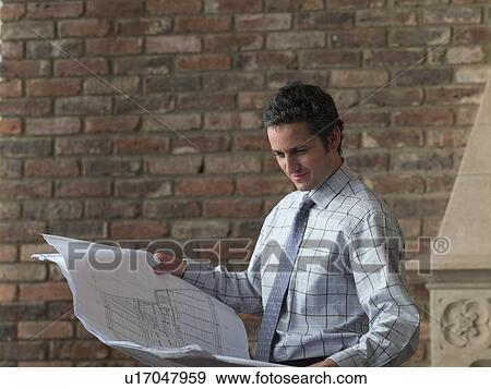 Businessman reading blueprints View Large Photo Image Stock Photo - Businessman reading blueprints. Fotosearch