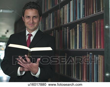 Businessman reading book in library View Large Photo Image Stock Image - Businessman reading book in library. Fotosearch