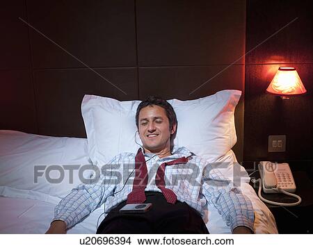 Picture - Businessman relaxing in hotel room. Fotosearch