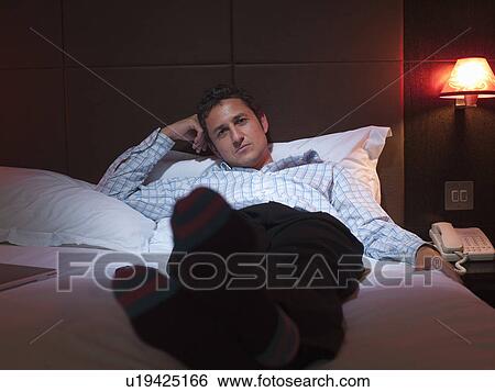 Stock Photograph - Businessman relaxing in hotel room. Fotosearch