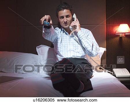 Businessman relaxing in hotel room View Large Photo Image Stock Photography - Businessman relaxing in hotel room. Fotosearch