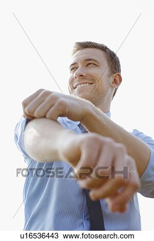 Businessman rolling up sleeves View Large Photo Image Stock Image - Businessman rolling up sleeves. Fotosearch
