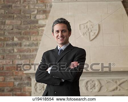 Picture - Businessman standing with arms crossed. Fotosearch