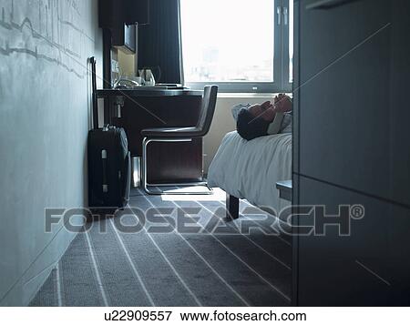 Stock Photo - Businessman talking on phone in hotel. Fotosearch