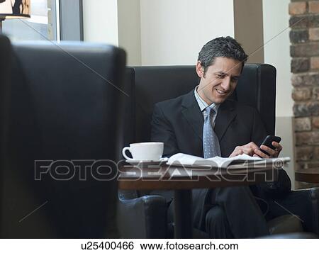 Businessman using cell phone in cafe View Large Photo Image Stock Photograph - Businessman using cell phone in cafe. Fotosearch