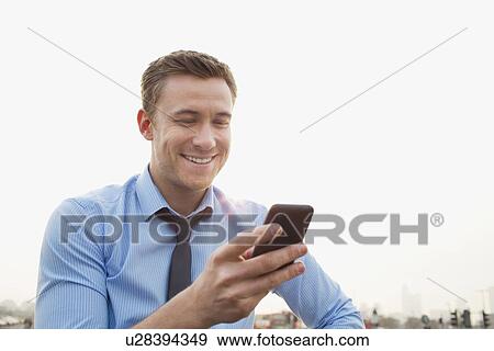 Businessman using cell phone outdoors View Large Photo Image Stock Photo - Businessman using cell phone outdoors. Fotosearch