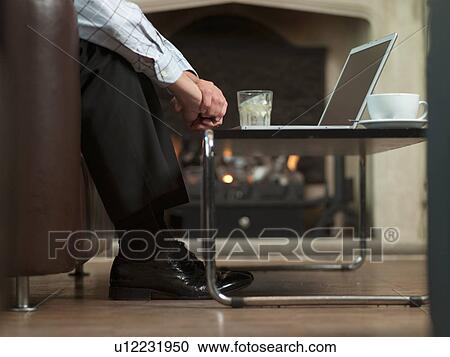 Stock Image - Businessman working on laptop at home. Fotosearch