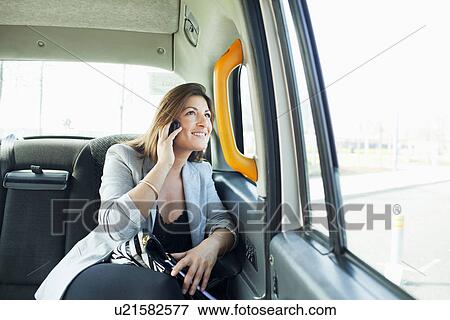 Businesswoman on cell phone in taxi View Large Photo Image Stock Photo - Businesswoman on cell phone in taxi. Fotosearch