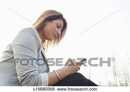 Businesswoman using cell phone outdoors View Large Photo Image Stock Photo - Businesswoman using cell phone outdoors. Fotosearch