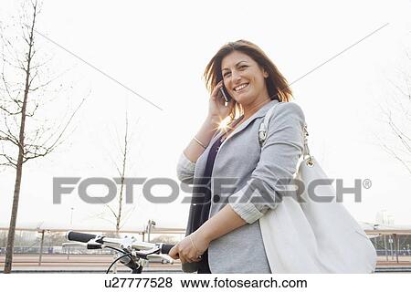 Businesswoman walking bicycle outdoors View Large Photo Image Stock Photo - Businesswoman walking bicycle outdoors. Fotosearch