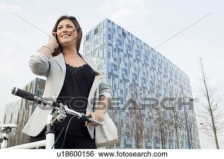 Businesswoman walking bicycle outdoors View Large Photo Image Stock Photograph - Businesswoman walking bicycle outdoors. Fotosearch