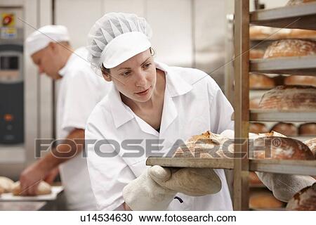 Chef carrying tray of bread in kitchen View Large Photo Image Stock Image - Chef carrying tray of bread in kitchen. Fotosearch