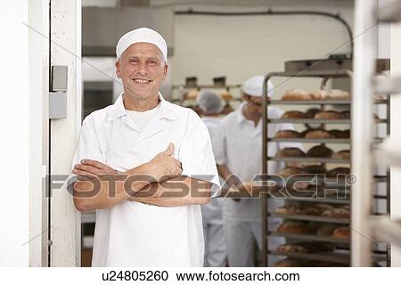Stock Image - Chef smiling in kitchen. Fotosearch