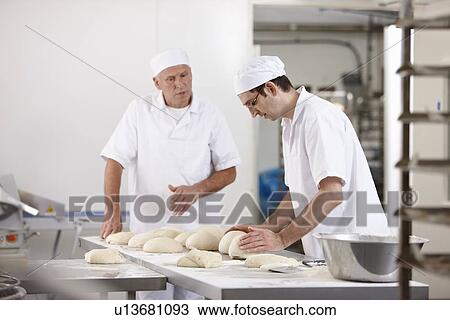 Stock Image - Chefs baking in kitchen. Fotosearch