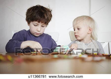 Stock Image - Children decorating gingerbread cookies. Fotosearch