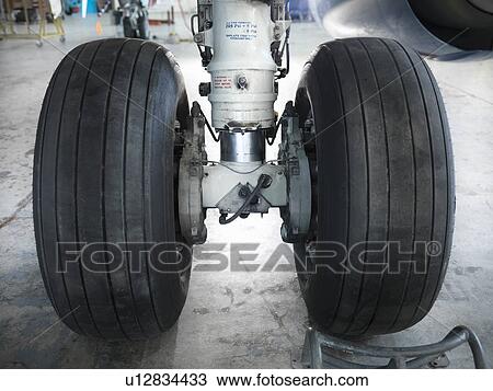 Stock Image - Close up of airplane wheels in hangar. Fotosearch