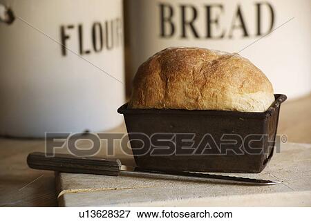 Stock Photo - Close up of bread in loaf tin. Fotosearch