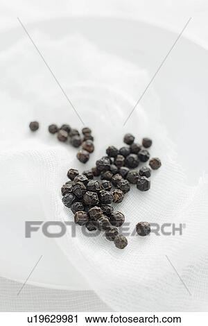 Stock Image - Close up of plate of peppercorns. Fotosearch