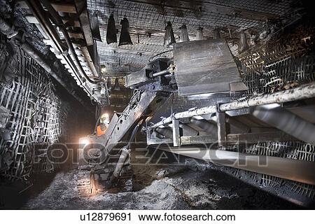 Stock Image - Coal miner working in mine. Fotosearch