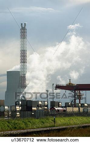 Stock Image - Containers on train by chemical plant. Fotosearch