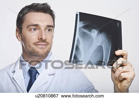 Doctor examining x-ray View Large Photo Image Stock Photo - Doctor examining x-ray. Fotosearch