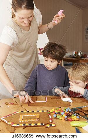 Family decorating gingerbread house View Large Photo Image Stock Photography - Family decorating gingerbread house. Fotosearch