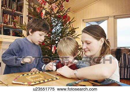 Family decorating gingerbread house View Large Photo Image Stock Photography - Family decorating gingerbread house. Fotosearch