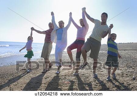 Stock Photo - Family holding hands on beach. Fotosearch