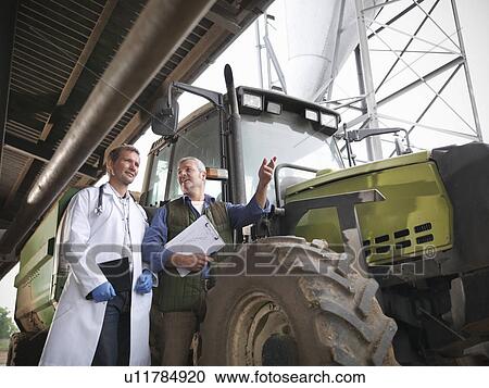 Farmer and veterinarian by tractor View Large Photo Image Stock Image - Farmer and veterinarian by tractor. Fotosearch