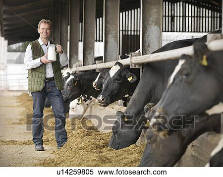 Farmer holding jug of milk by barn View Large Photo Image Stock Photography - Farmer holding jug of milk by barn. Fotosearch