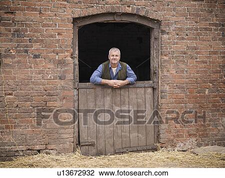 Farmer standing at gate of barn View Large Photo Image Stock Image - Farmer standing at gate of barn. Fotosearch