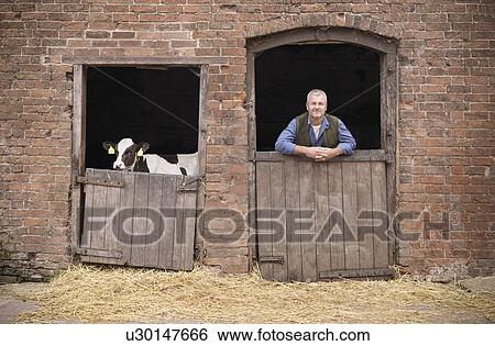Farmer standing at gate of barn View Large Photo Image Stock Photograph - Farmer standing at gate of barn. Fotosearch