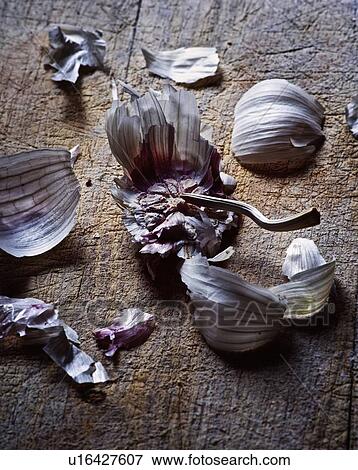 Garlic cloves and skin on wooden board View Large Photo Image Stock Photo - Garlic cloves and skin on wooden board. Fotosearch