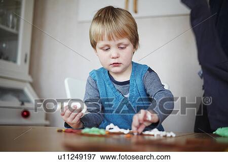 Girl decorating gingerbread cookies View Large Photo Image Stock Photo - Girl decorating gingerbread cookies. Fotosearch