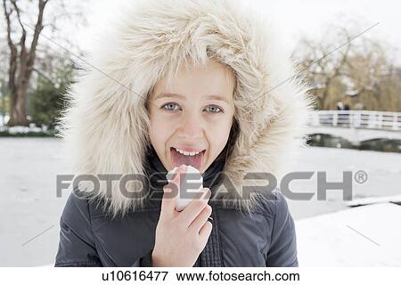 Girl in fur hood licking snow View Large Photo Image Stock Photo - Girl in fur hood licking snow. Fotosearch