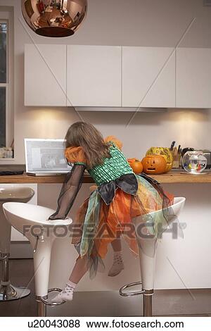 Girl in Halloween costume in kitchen View Large Photo Image Stock Photo - Girl in Halloween costume in kitchen. Fotosearch