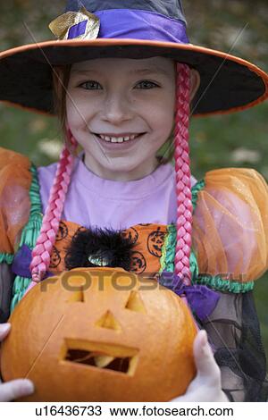 Girl in Halloween costume with pumpkin View Large Photo Image Stock Image - Girl in Halloween costume with pumpkin. Fotosearch