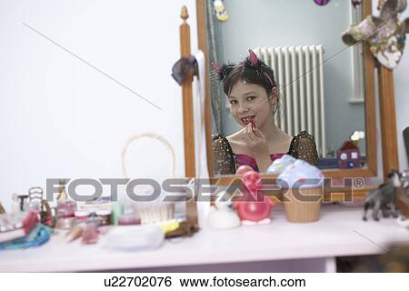 Stock Photograph - Girl putting on Halloween costume. Fotosearch