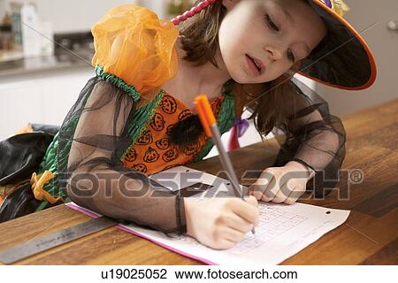 Stock Image - Girl studying in Halloween costume. Fotosearch
