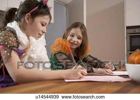 Girls studying in Halloween costumes View Large Photo Image Stock Photo - Girls studying in Halloween costumes. Fotosearch