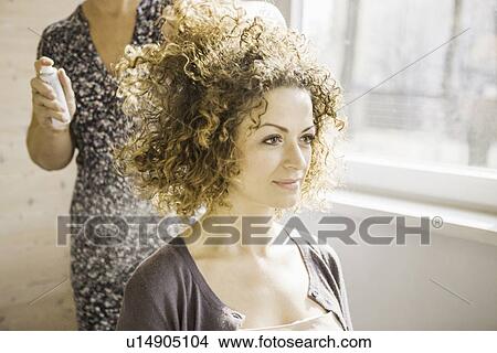Picture - Hair stylist working on client. Fotosearch