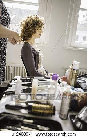 Stock Image - Hair stylist working on client. Fotosearch