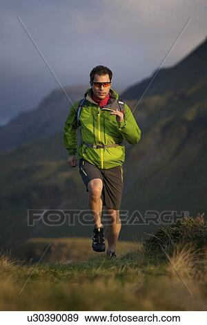 Stock Photo - Hiker running in grassy field. Fotosearch